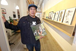 Owen Ela holds one of his favorite albums by SZA at his indie record store Resident Vinyl.