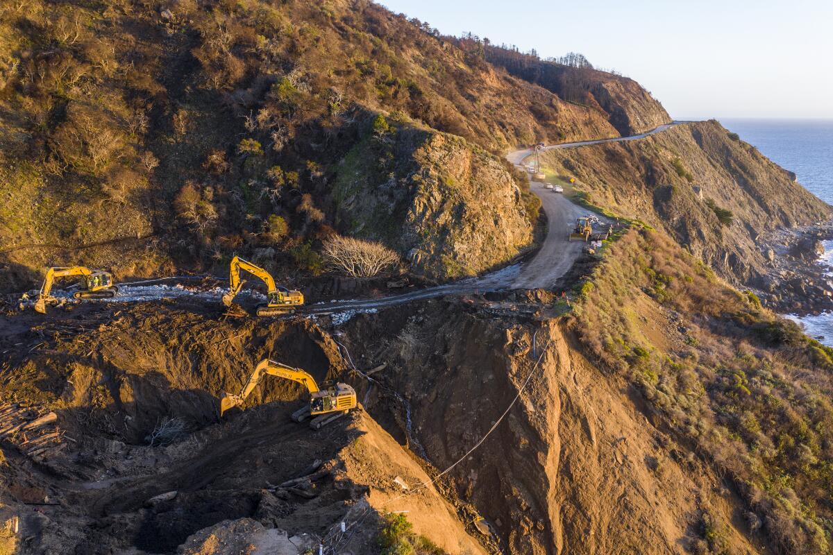 Crews dig debris from a washed-out section of Highway 1 on Feb. 10, 2021.