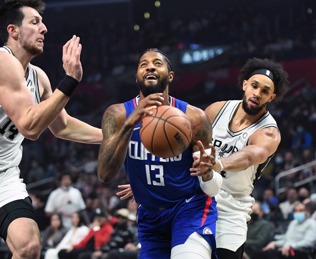 Clippers' Paul George is fouled by San Antonio Spurs' Derrick White while driving to the basket.