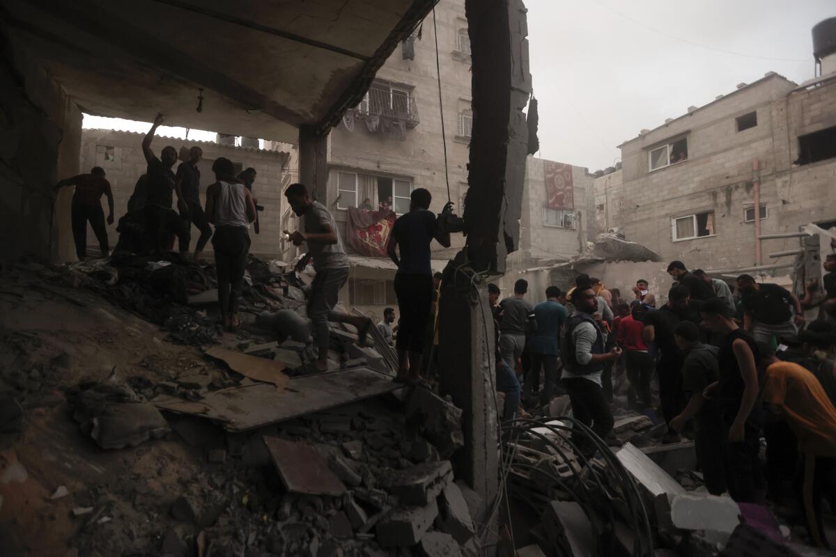Palestinians look for survivors under the rubble of a destroyed house following an Israeli airstrike.