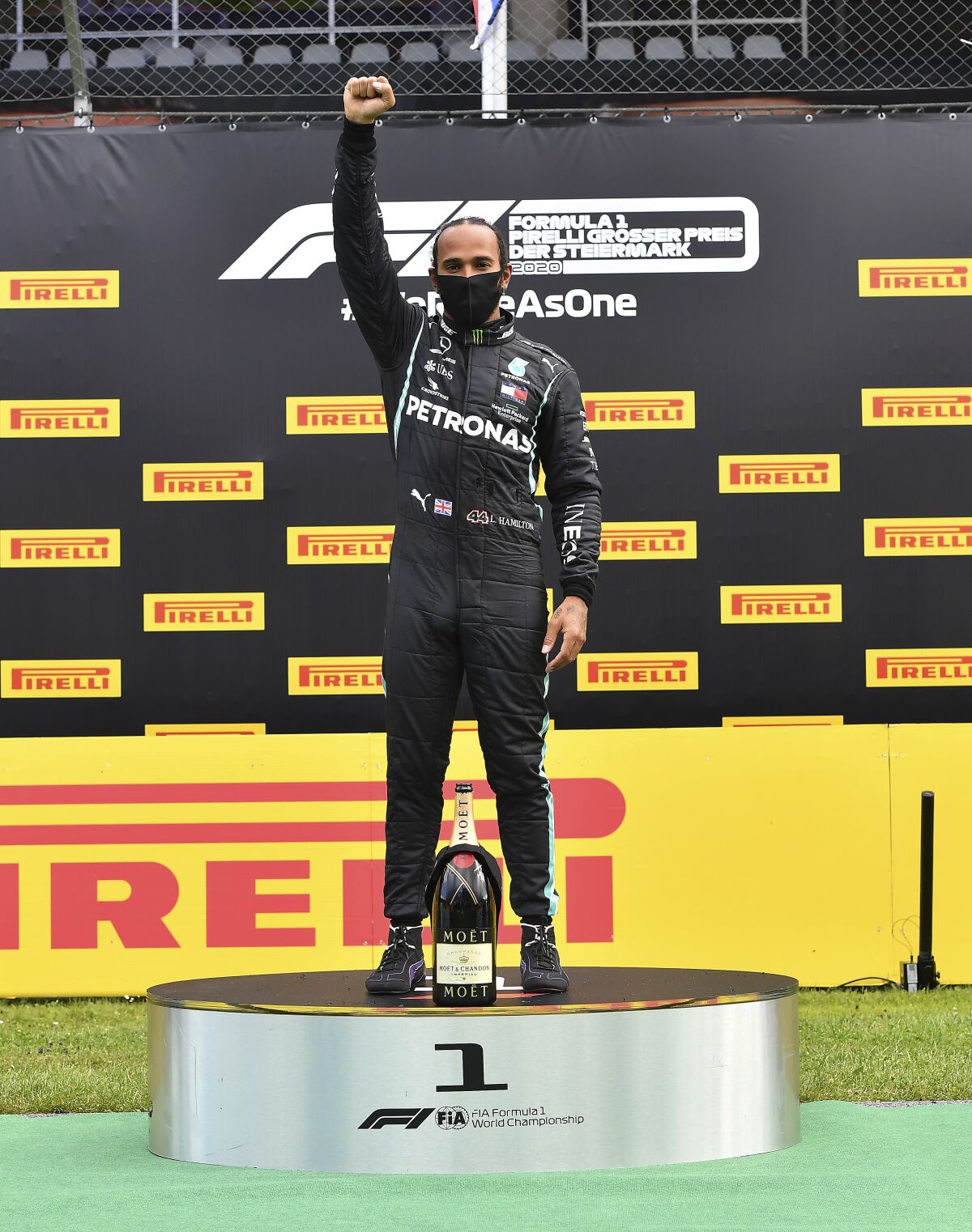 Formula One's Lewis Hamilton raises his right fist on the podium in Spielberg, Austria.