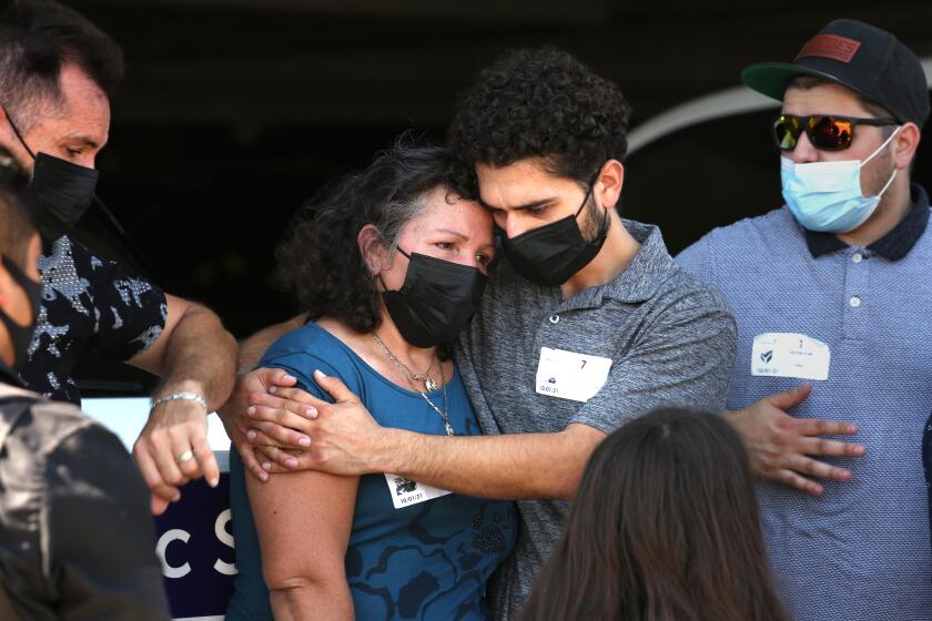 Long Beach, California-Oct. 1, 2021-Manuela Sahagun, left, mother of Mona Rodriguez, is hugged by Oscar Rodriguez, brother of Mona Rodriguez, after a press conference on Friday, October 1, 2021. The family of Mona Rodriguez appears outside Long Beach Memorial Care Hospital, where Rodriguez was taken off life support today. Mona Rodriguez, age 18, was shot by a Long Beach Public safety officer as she sat in the passenger seat of a car unarmed. (Carolyn Cole / Los Angeles Times)