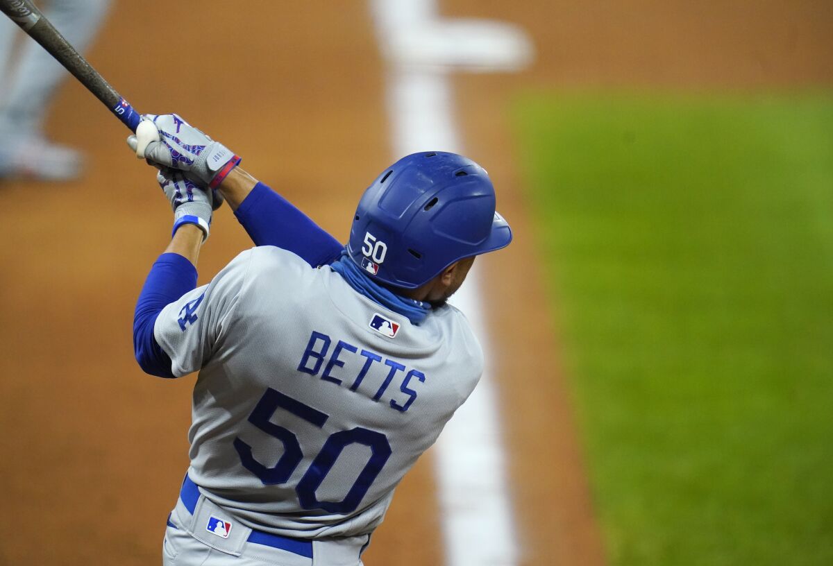 Los Angeles Dodgers' Mookie Betts watches his two-run triple off Colorado Rockies relief pitcher.