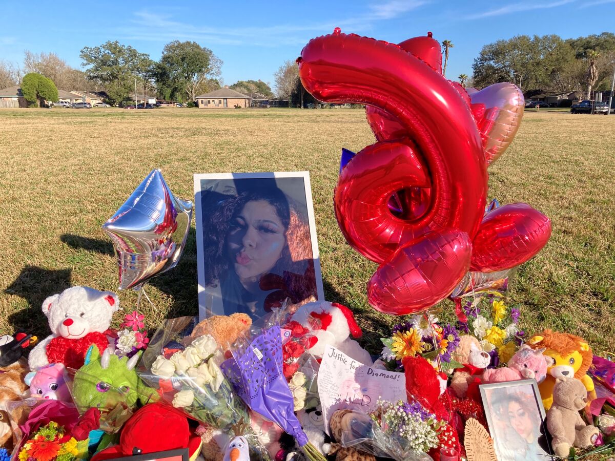 A makeshift memorial sits near the side of a street, Thursday, Jan 13, 2022, in Houston, next to a large grassy area where Diamond Alvarez was fatally shot. Police continue looking for who fatally shot the 16-year-old Houston girl as she walked her dog. (AP Photo/Juan Lozano)