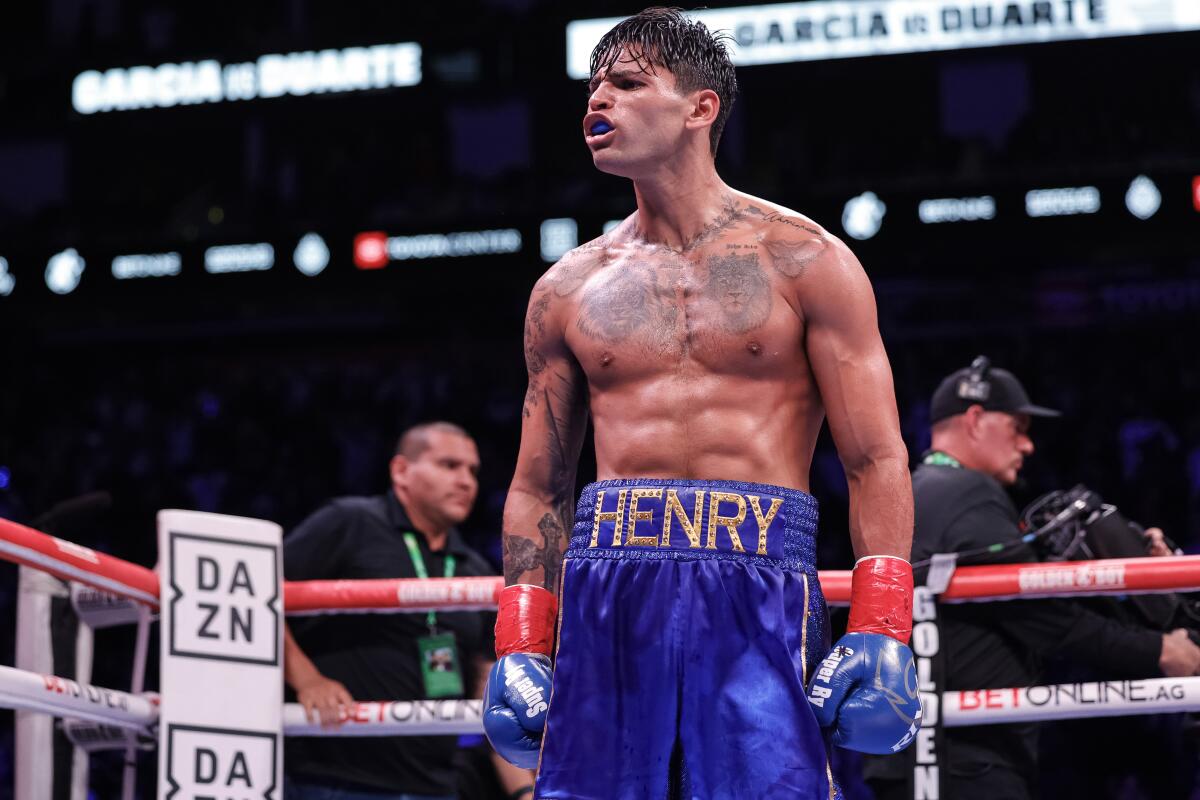 Welterweight Ryan Garcia wears cobalt trunks with the name "Henry" across the waist and matching gloves in the boxing ring
