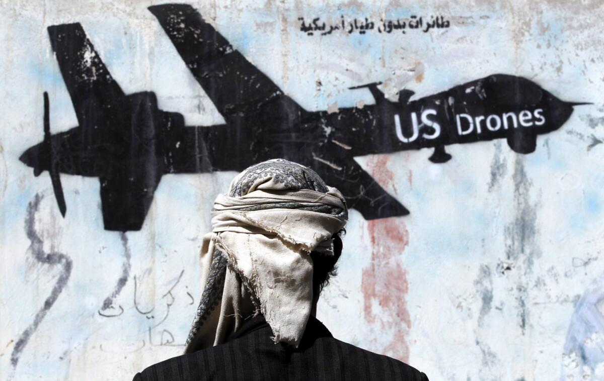 A Yemeni stands in front of a graffiti protesting U.S. military operations in Sana'a, Yemen on Jan. 29, 2017.