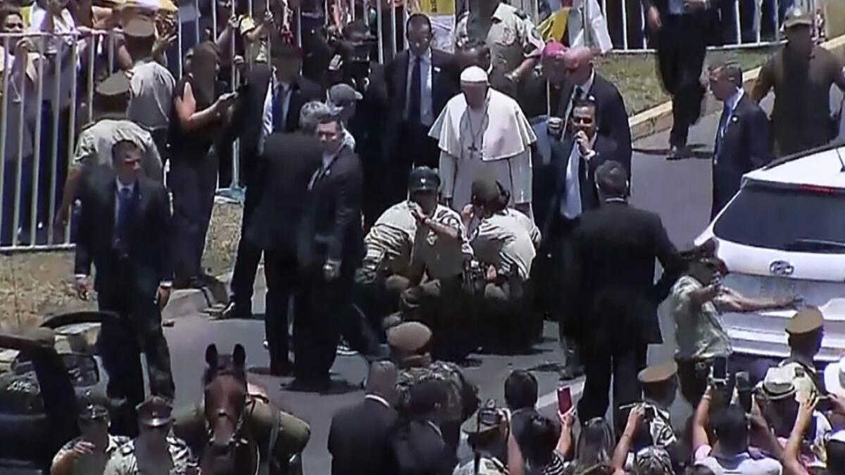Pope Francis checks on the fallen police officer. She was not seriously injured.
