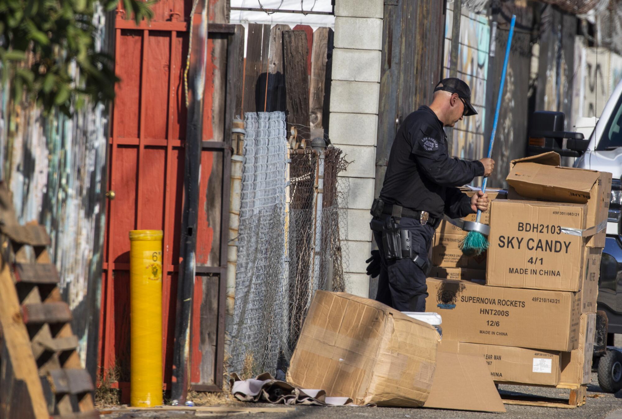 An officer stands next to cardboard boxes.