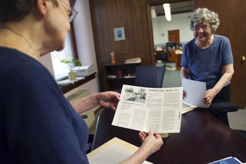 Las monjas Rose Marie Stallbaumer (i) y Barbara McCracken (d) examinan propuestas para resoluciones corporativas y artículos de prensa en el convento Mount St. Scholastica en Atchison, Kansas, el 16 de julio del 2024. (Foto AP/Jessie Wardarski)