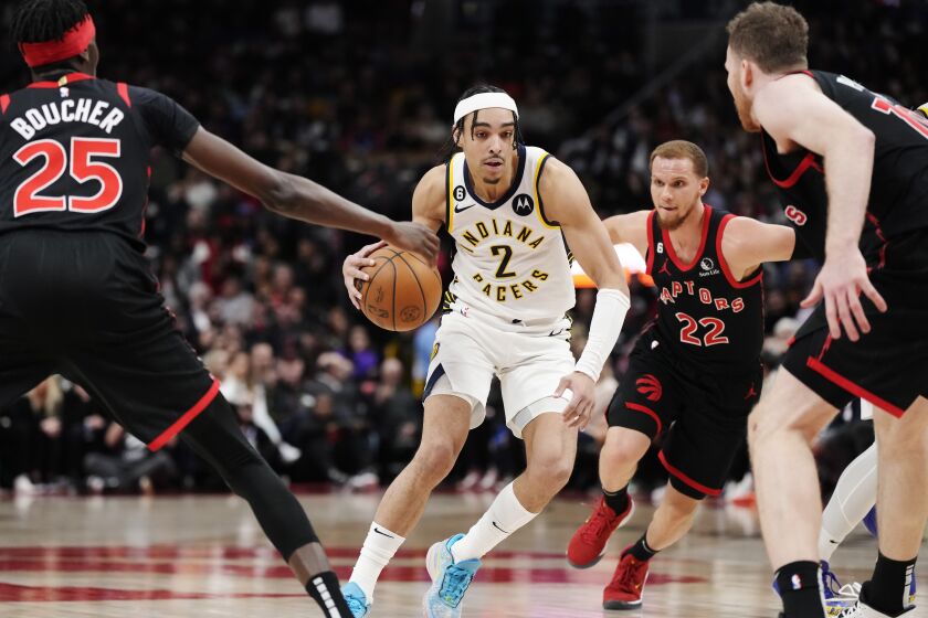 Indiana Pacers guard Andrew Nembhard (2) drives between Toronto Raptors forward Chris Boucher (25), guard Malachi Flynn (22) and centre Jakob Poeltl (19) during the second half of an NBA basketball game in Toronto, Wednesday, March 22, 2023. (Frank Gunn/The Canadian Press via AP)
