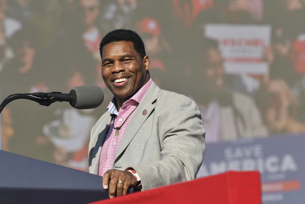 FILE - Herschel Walker, front-runner for the party's U.S. Senate nominee, speaks during a rally for Georgia GOP candidates at Banks County Dragway in Commerce, Ga., Saturday, March 26, 2022. In his run for U.S. Senate in Georgia, former football great Herschel Walker has gone to great lengths so far to dodge tough questions. The GOP candidate does not widely publicize his campaign stops and limits his appearances mostly to conservative news outlets and friendly audiences. Earlier this month, he skipped the first debate for the May 24 Republican primary. (Hyosub Shin/Atlanta Journal-Constitution via AP, File)
