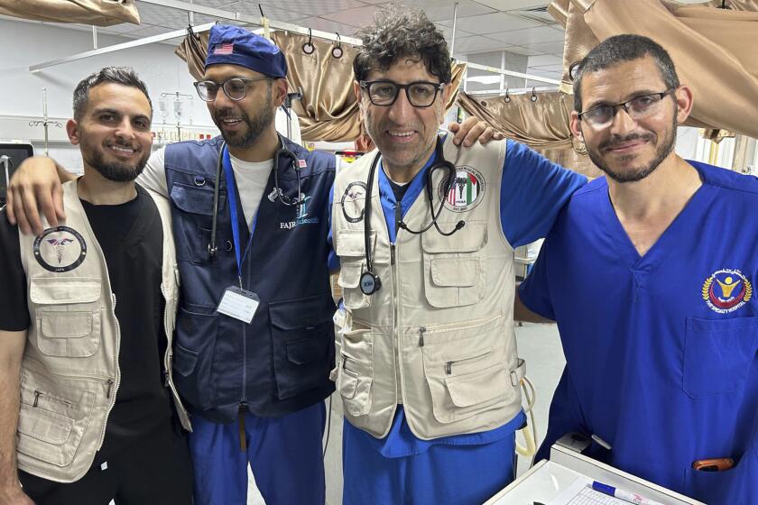 El doctor Ammar Ghanem, especialista en cuidados intensivos de Detroit y voluntario de la Sociedad Médica Sirio-Estadounidense en uno de los últimos hospitales en funcionamiento de Gaza, segundo por la derecha, posa el 7 de mayo de 2024 en Jan Yunis, Gaza, con un médico palestino y otros dos médicos estadounidenses voluntarios en el Hospital General Europeo, donde se encuentran desde mayo. (Sin crédito)