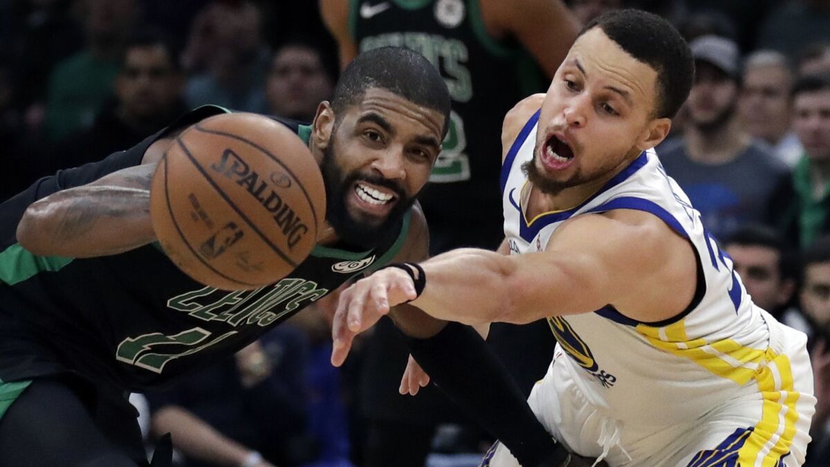 Golden State Warriors guard Stephen Curry, right, attempts to steal the ball from Boston Celtics guard Kyrie Irving (11) in the fourth quarter.