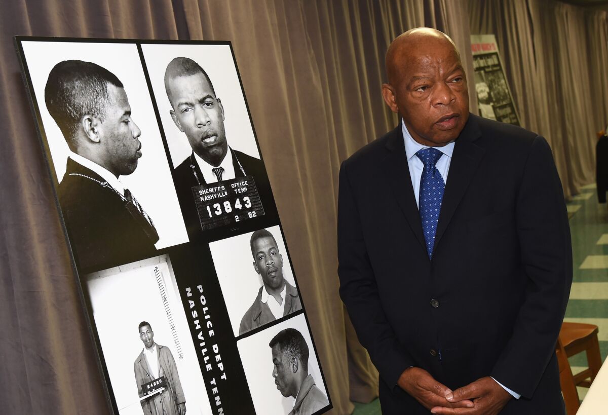 Rep. John Lewis in 2017 with images of his arrest for leading a sit-in at Nashville's segregated lunch counters in 1963.