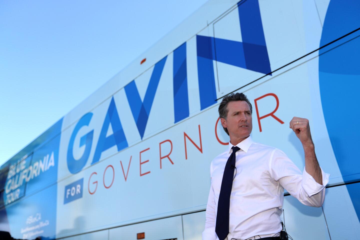 Lt. Gov. Gavin Newsom speaks to his staff as he boards his bus at a rally for congressional candidate Katie Hill and Assembly candidate Christy Smith.