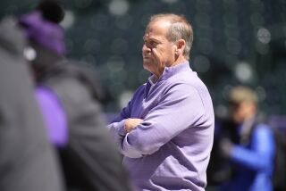 Colorado Rockies co-owner Dick Monfort looks on as players warm up for the team's regular-season home opener Thursday, April 7, 2022, in Coors Field in Denver. The Rockies host the Los Angeles Dodgers Friday to kick off a three-game weekend set. (AP Photo/David Zalubowski)