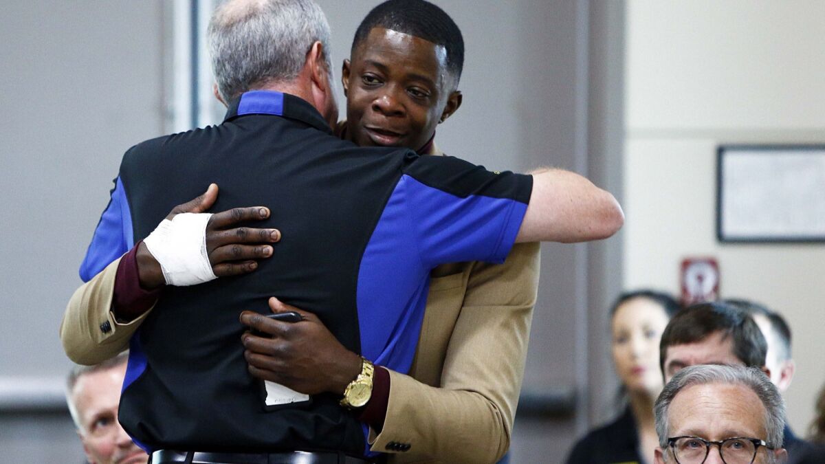 James Shaw Jr., right, gets a hug from Waffle House Chief Executive Walter Ehmer. Shaw wrestled the gun from the shooter.