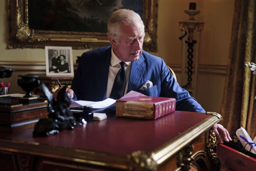 En esta imagen del 11 de septiembre de 2022, el rey Carlos III de Inglaterra desempeña sus tareas oficiales en una sala del Palacio de Buckingham, en Londres. (Victoria Jones/PA vía AP)