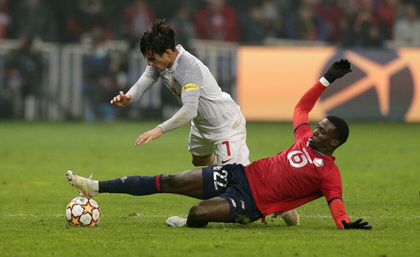 Lille's Timothy Weah, right, and Salzburg's Nicolas Capaldo challenge for the ball during the Champions League group G soccer match between OSC Lille and RB Salzburg at the Stade Pierre Mauroy - Villeneuve d'Ascq in Lille, France, Tuesday, Nov. 23, 2021. (AP Photo/Michel Spingler)