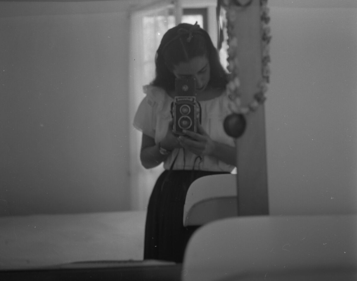 A 1951 black-and-white photo shows Luchita Hurtado taking a self-portrait in a mirror.