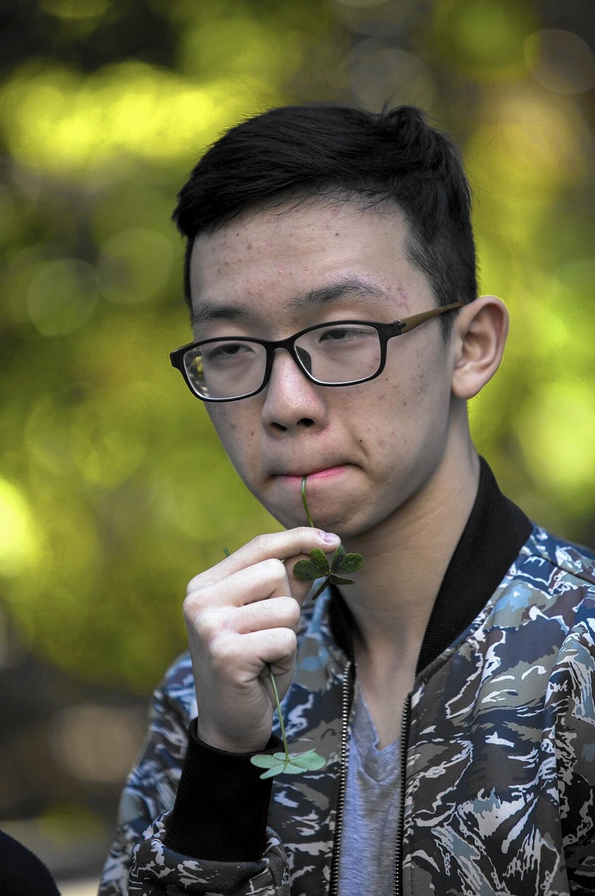 Haowen Yang, a student from Experimental High School in Beijing, chews on an edible plant during a visit Wednesday to the Environmental Nature Center in Newport Beach.