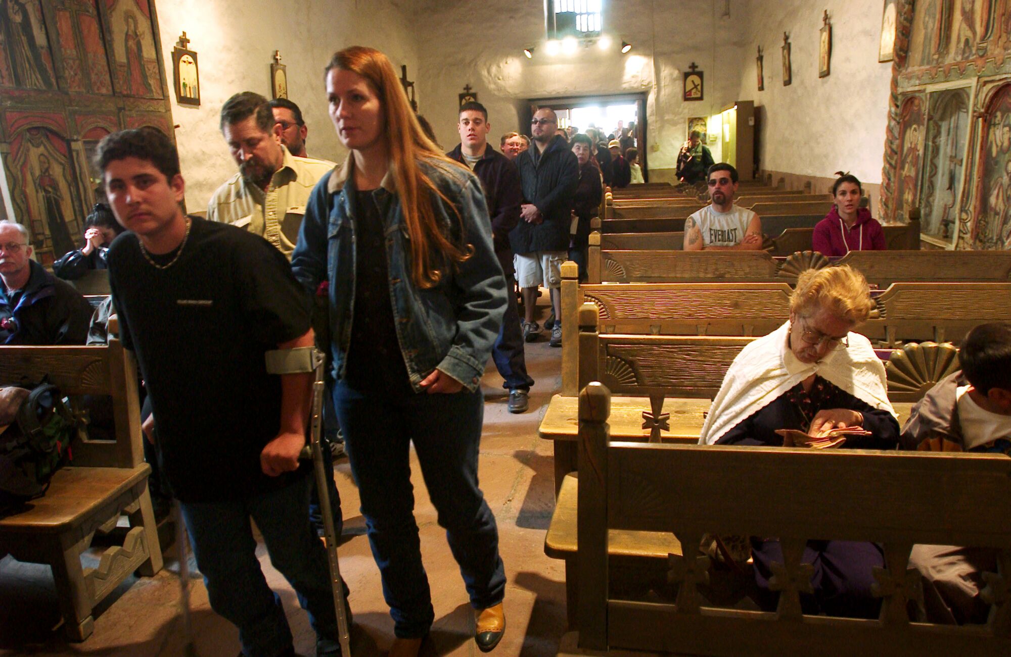 Pilgrims pray before the altar of the Santuario de Chimayo Church in Chimayo