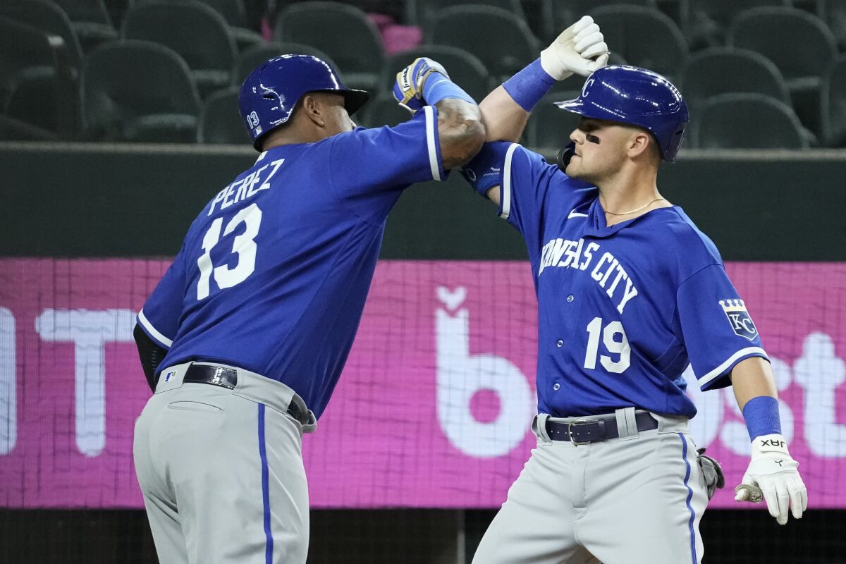 Kansas City Royals' Michael Massey (19) is congratulated by teammate Salvador Perez (13) after hitting a home run during the fourth inning of a spring training baseball game against the Texas Rangers, Monday, March 27, 2023 in Arlington, Texas. (AP Photo/Sam Hodde)
