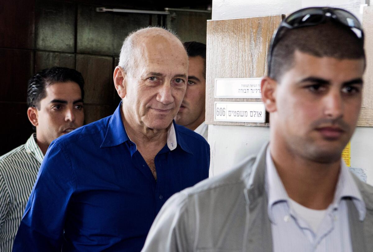 Former Israeli Prime Minister Ehud Olmert, center, leaves Tel Aviv District Court after receiving a prison sentence on a bribery conviction.