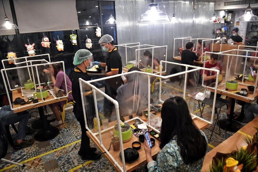 TOPSHOT - People eat in between plastic partitions, set up in an effort to contain any spread of the COVID-19 coronavirus, at the Penguin Eat Shabu hotpot restaurant in Bangkok on May 5, 2020. (Photo by Lillian SUWANRUMPHA / AFP) (Photo by LILLIAN SUWANRUMPHA/AFP via Getty Images)