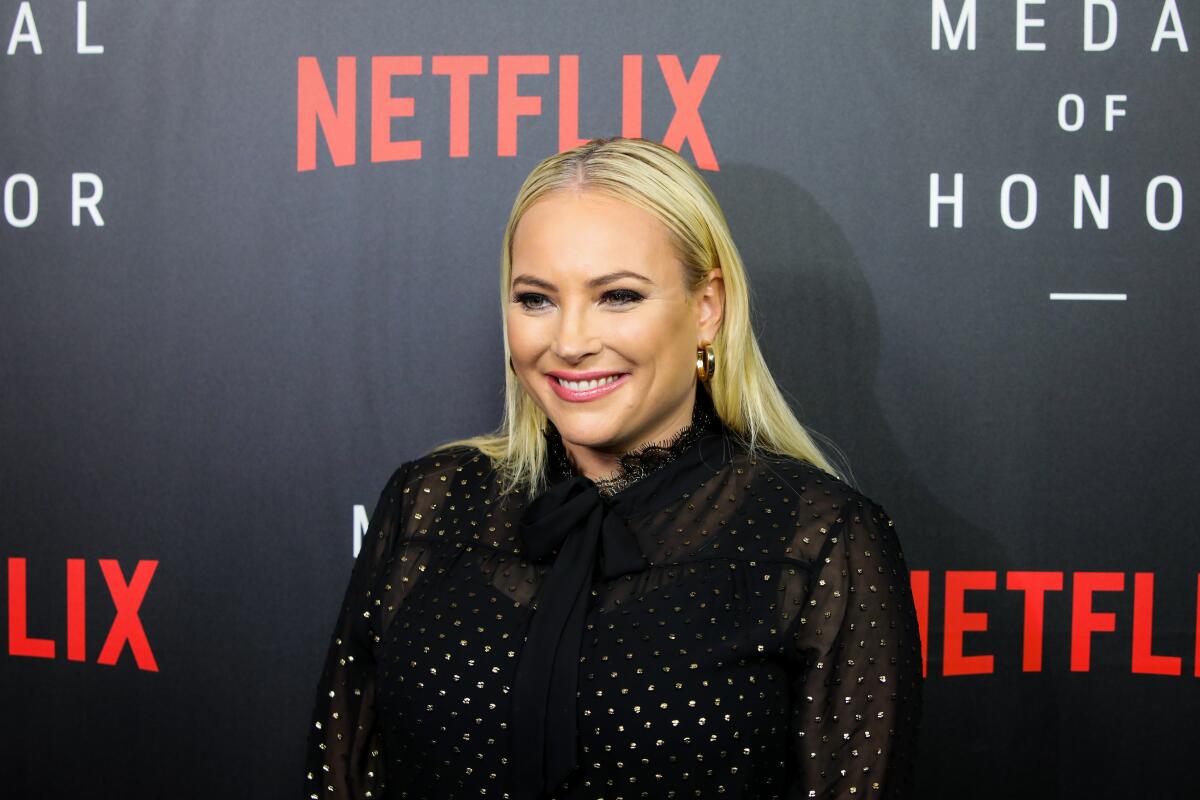 A blonde woman in a high-necked black dress