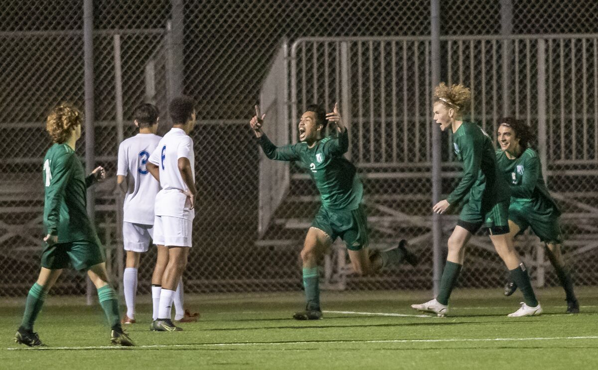 Edison's Nathan Peterson, center, celebrates a goal against Fountain Valley during a Surf League boys' soccer match.