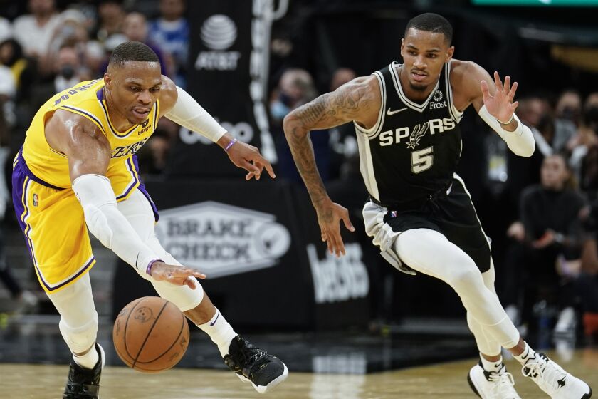 Los Angeles Lakers' Russell Westbrook, left, and San Antonio Spurs' Dejounte Murray chase ball during an NBA basketball game