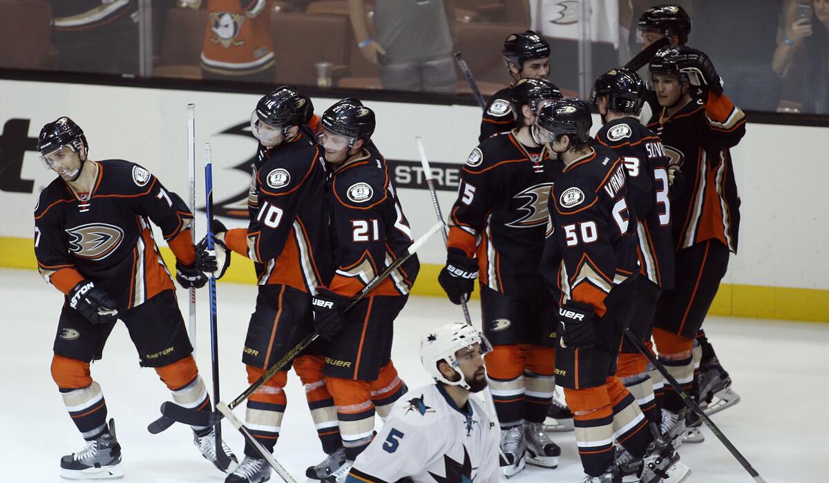 Ducks players celebrate a game-inning goal by right wing Corey Perry (10) to defeat the San Jose Sharks during the overtime period of a preseason game Sunday.