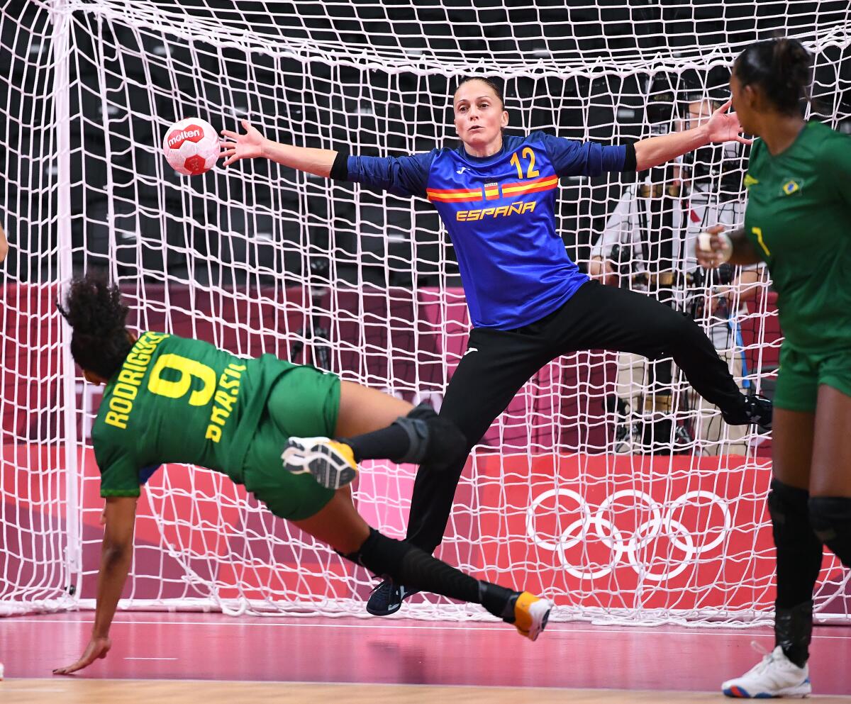 Brazil's Ana Rodrigues makes a handball score on Spain goalkeeper Silvia Navarro at the Tokyo Olympics.