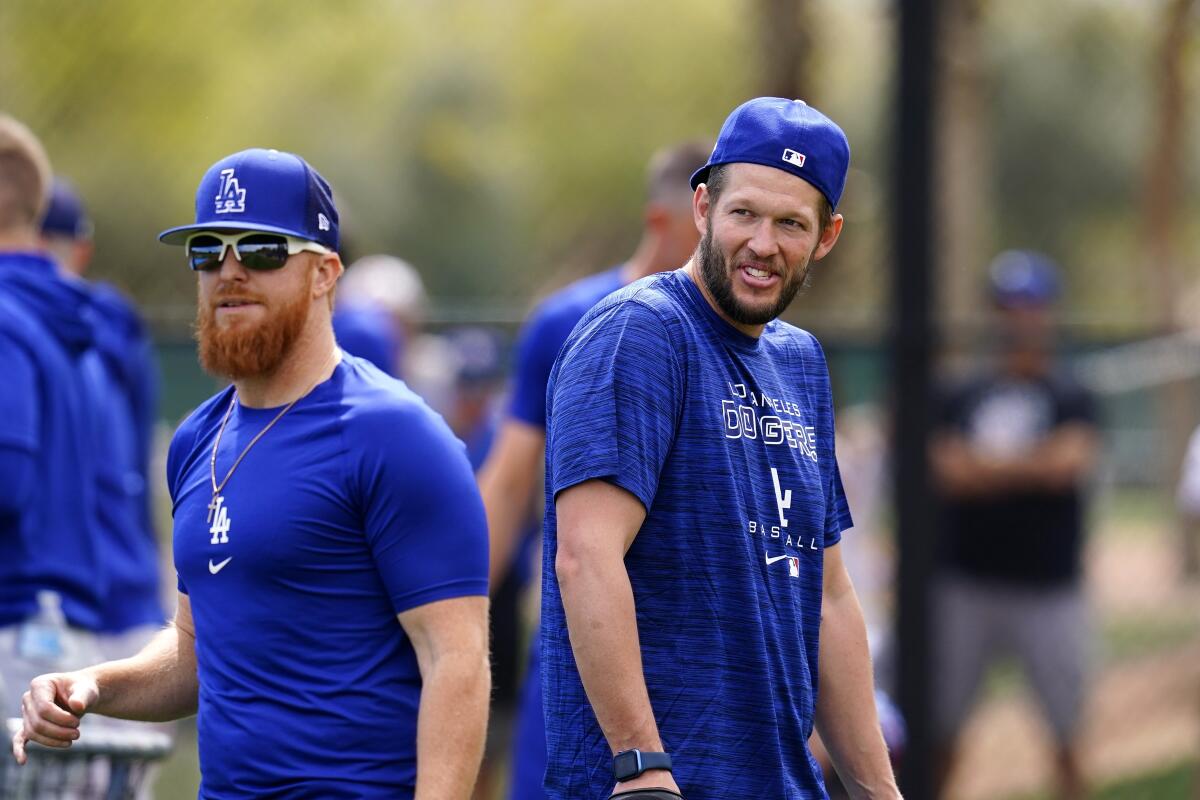 Los Angeles Dodgers' Justin Turner, left, wait to catch a ball as Clayton Kershaw walks behind him