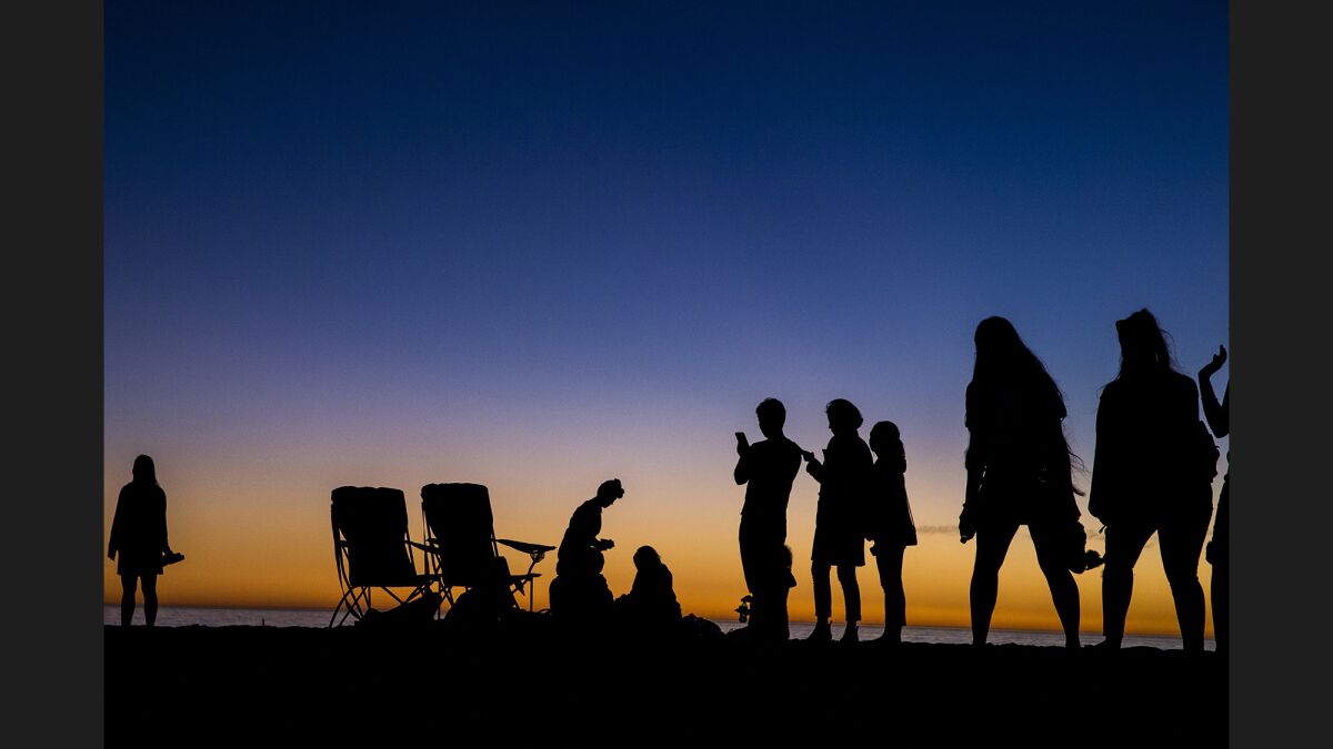 Beachgoers are cast in silhouette on Santa Monica Beach in November 2017.