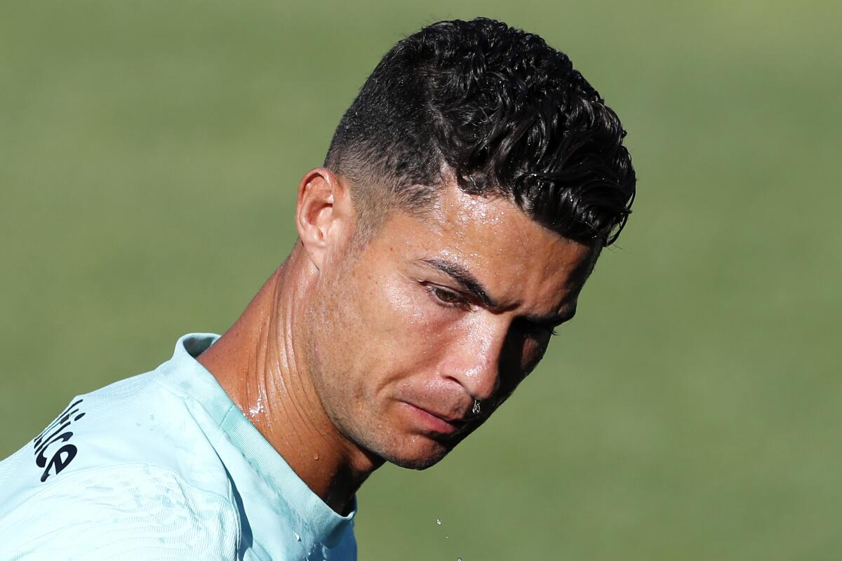 Portugal's Cristiano Ronaldo looks on after wetting his face with water, during a training session in Oeiras, Portugal, Monday, Aug. 30, 2021. Portugal will play Ireland on Wednesday in a Qatar 2022 World Cup qualifying match. (AP Photo/Armando Franca)