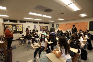 LYNWOOD, CA - OCTOBER 28, 2021 - - Audrey Casas, left, te3aches students during a English Pre-AP 9 class in a portable classroom at Lynwood High School - Bullis on October 28, 2021. Close to 1900 students are currently attending school at this campus since Lynwood High School - Imperial suffered a building collapse that happened in June 2020. Officials are still assessing the damage and impact of the construction failure on the local educational community. Lynwood High School, a relatively new flagship campus in the Lynwood Unified School District, was condemned as unsafe to use after further investigation proved some parts of the school structurally unsound.(Genaro Molina / Los Angeles Times)