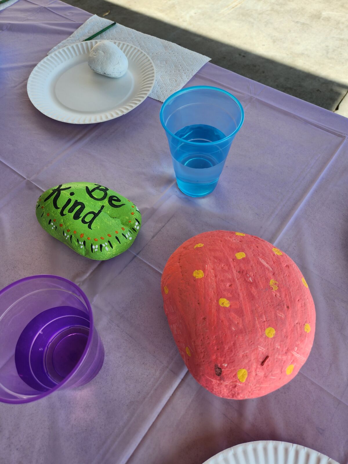 Rock painting at the open house tribute. Painted rocks will be placed in the garden reading area.