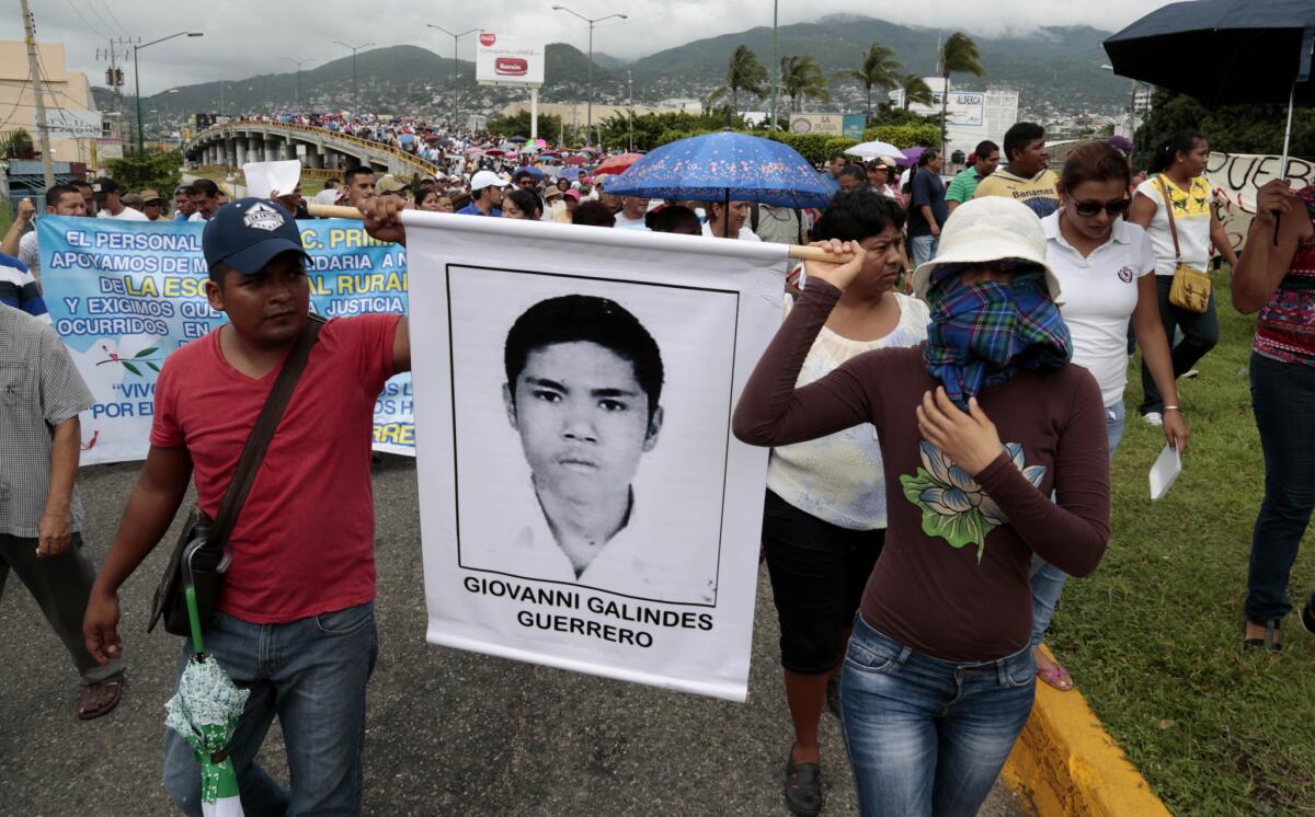 Masked demonstrators march with photographs of missing students to protest the disappearance of 43 students from the Isidro Burgos rural teachers college in Guerrero state, Mexico.