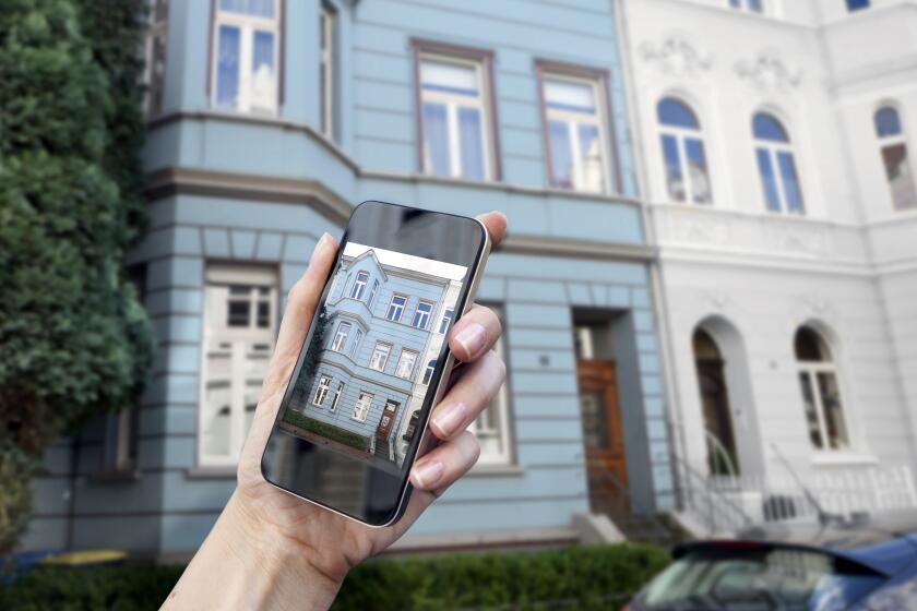Hand with smart phone displaying a historic house front, showing in the background, w27, Bonn, Germany