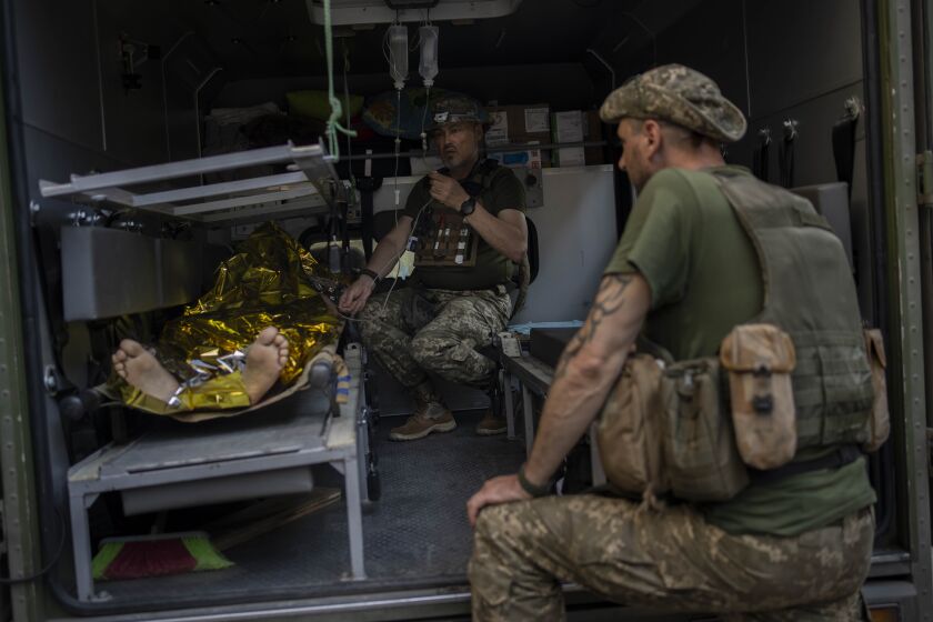 An injured Ukrainian servicemen is transferred to a medical facility after getting an emergency medical treatment in the Donetsk region, eastern Ukraine, Tuesday, June 7, 2022. (AP Photo/Bernat Armangue)
