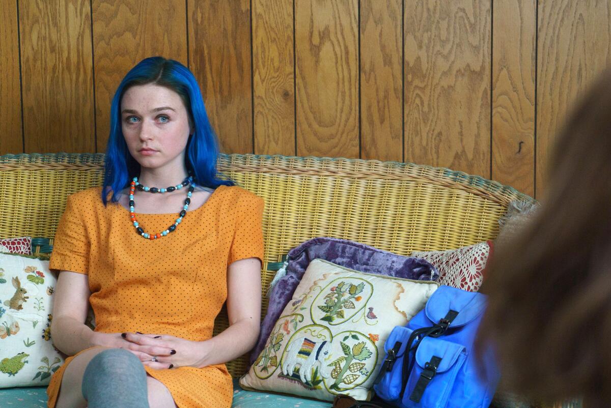 Jessica Barden sits on a couch in a scene from "Pink Skies Ahead"