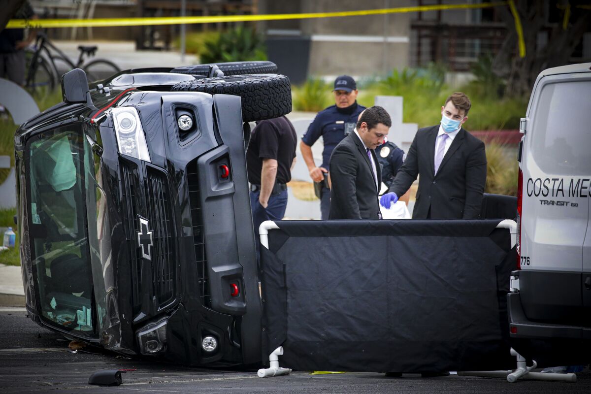 Police in Costa Mesa investigate the site where a person was killed early Thursday when a pickup overturned.