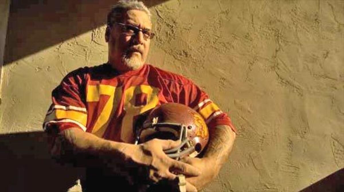 SHOW STOPPER: George Achica (78) was a force at nose guard for USC in 1981. Against UCLA, Achica blocked a 46-yard field goal on the last play of the game. Above, the former football player poses in his jersey and helmet outside his home in San Jose, California.