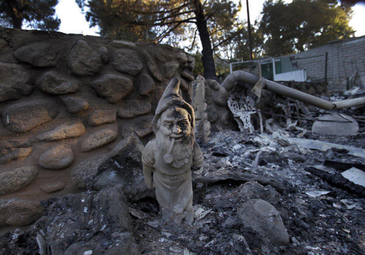 A gnome stands at the entrance of a burned-out home on Aug. 9 in the Poppet Flats neighborhood, after the Silver fire burned 26 homes and seriously injured one person.