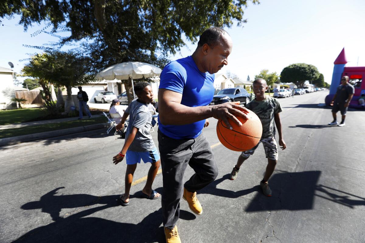 Inglewood Mayor James T. Butts Jr. plays basketball with boys while attending a block club party in September. He is campaigning for reelection.