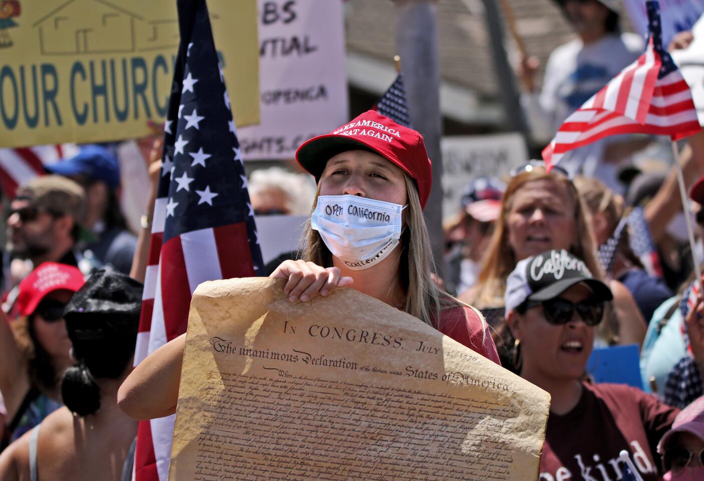 Protester holds a copy of the Declaration of Independence up during the protest in Huntington Beach on Friday.