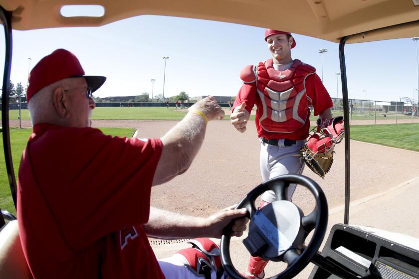 Angels catching coordinator Bill Lachemann greets then-minor league catcher Jett Bandy before a spring training game in 2013. The Angels on Thursday added Bandy to its 40-man roster.