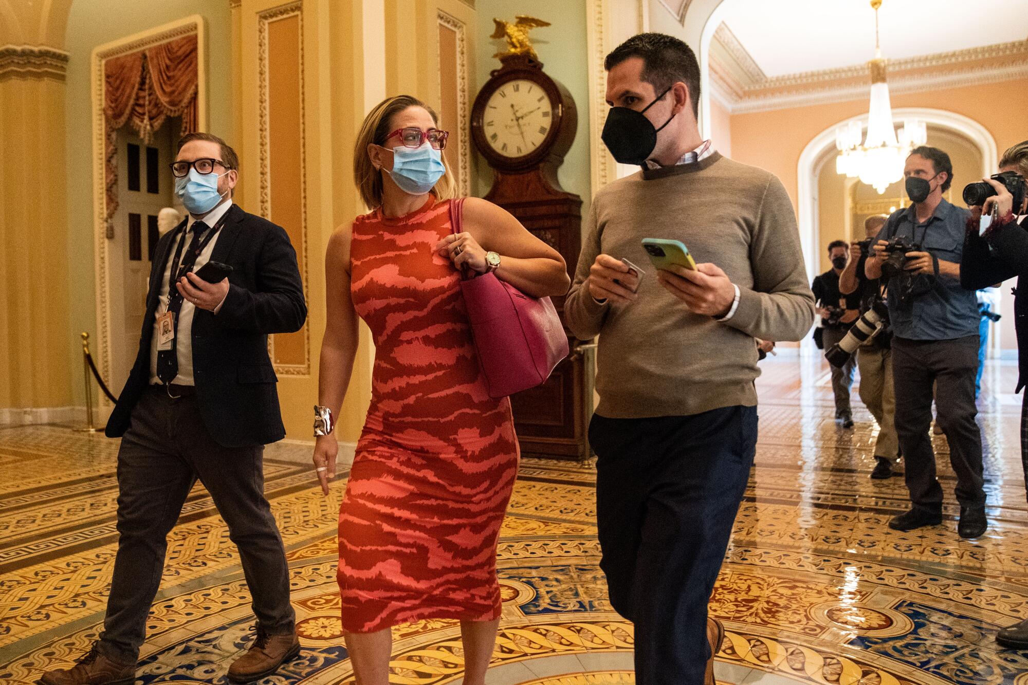 Kyrsten Sinema talks with a man holding a cellphone